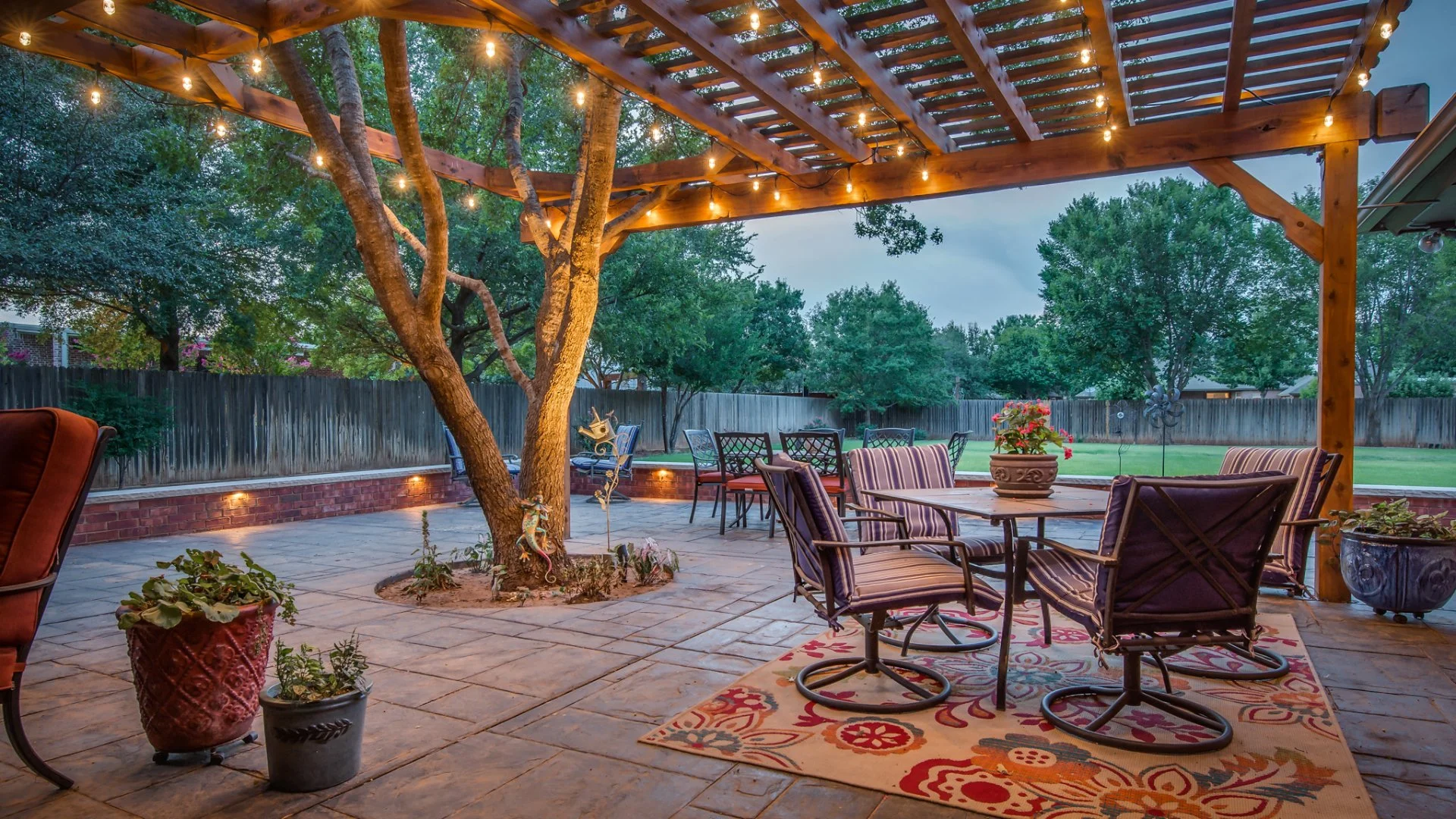 Outdoor living space with paver patio and tree growing through the middle.