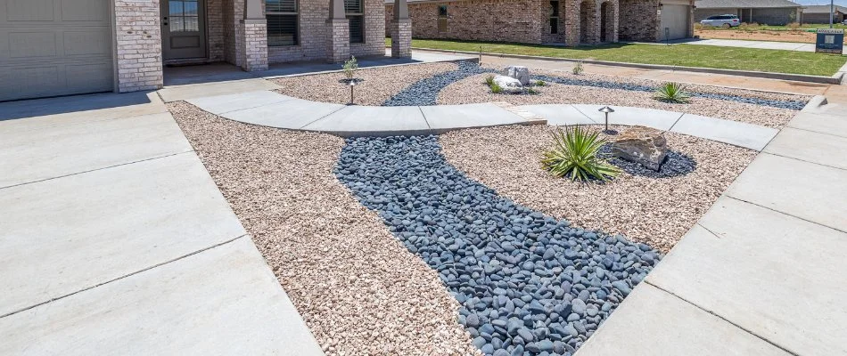 Xeriscape in Lubbock, TX, with rocks and drought tolerant plants.