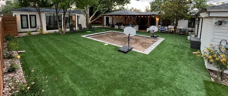 Artificial turf and a covered pool in a backyard in Lubbock, TX.