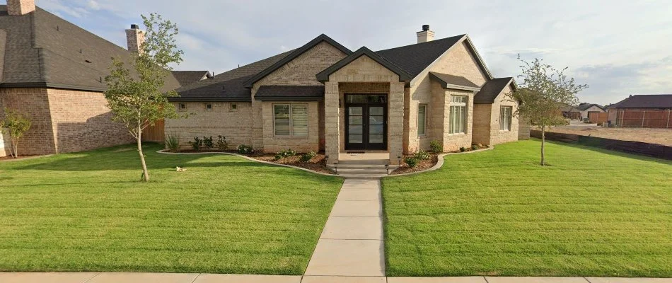 House in Littlefield, TX, with lush green grass.