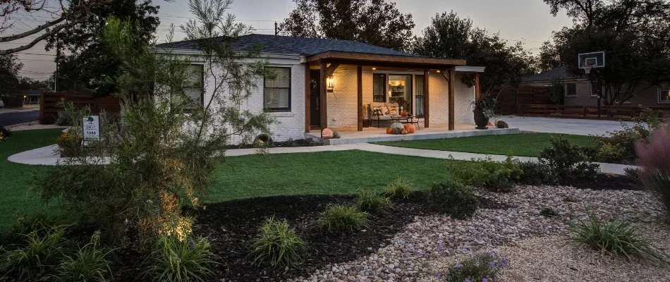 House in Lubbock, TX, with a patio, artificial turf, and xeriscape.