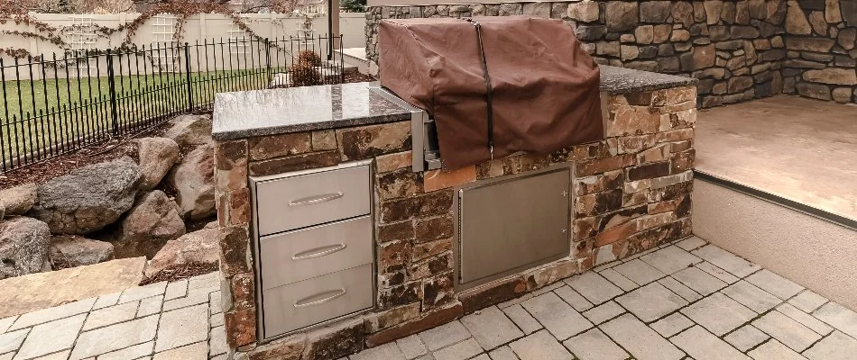 Outdoor kitchen with grill cover and drawers on a property in Lubbock, TX.
