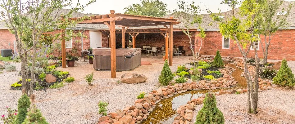 Yard with rocks, small plants, and pergola on a property in Lubbock, TX.